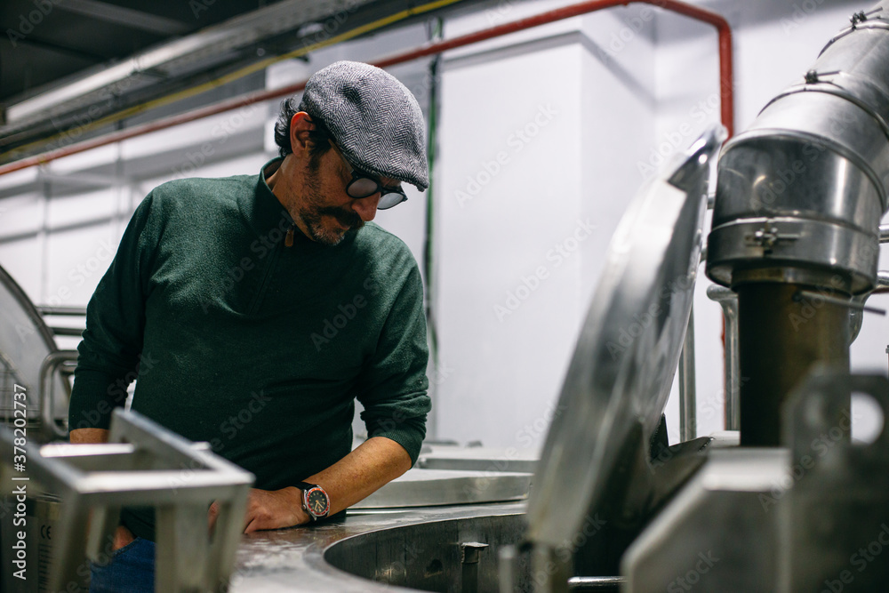 Man watching brewing process on factory Man watching brewing process on factory