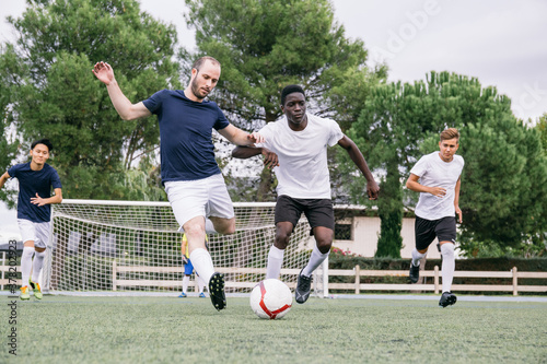 Group of men playing football on field photo