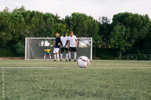 Football players forming wall to defend free kick