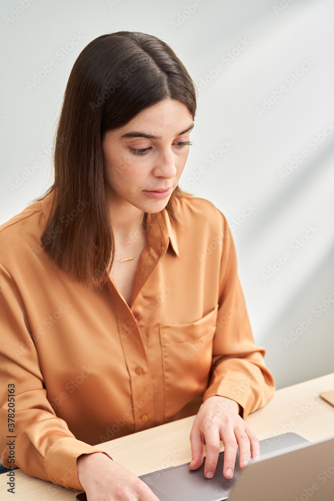 Serious freelancer with laptop working on remote project Serious freelancer with laptop working on remote project
