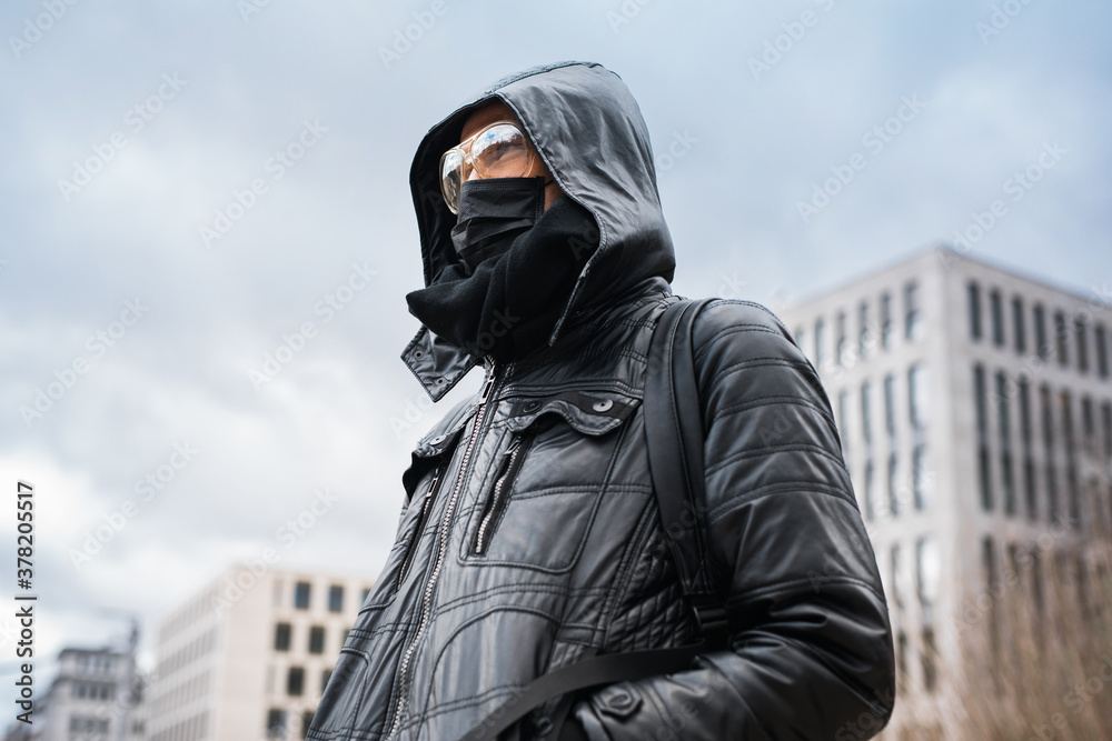 Man wearing black medical mask and goggles outside Man wearing black medical mask and goggles outside