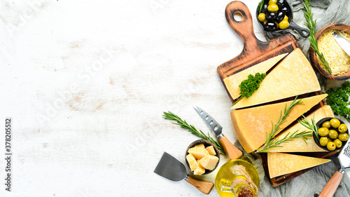 Assortment of hard cheeses on white wooden background. Parmesan. Top view. Free space for your text.