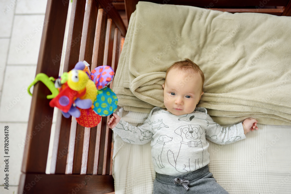 Cute three months old baby boy playing with his colourful toys outdoor. Cute three months old baby boy playing with his colourful toys outdoor.