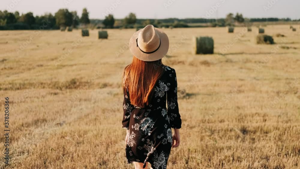 Playful redhaired girl walks among windy straw field. Girl In Hat Enjoying Weekend. Happy Ginger Girl is spinning ti the Camera with happy Smile, Summer Face Female. Emotions. People. Portrait. Playful redhaired girl walks among windy straw field. Girl In Hat Enjoying Weekend. Happy Ginger Girl is spinning ti the Camera with happy Smile, Summer Face Female. Emotions. People. Portrait.