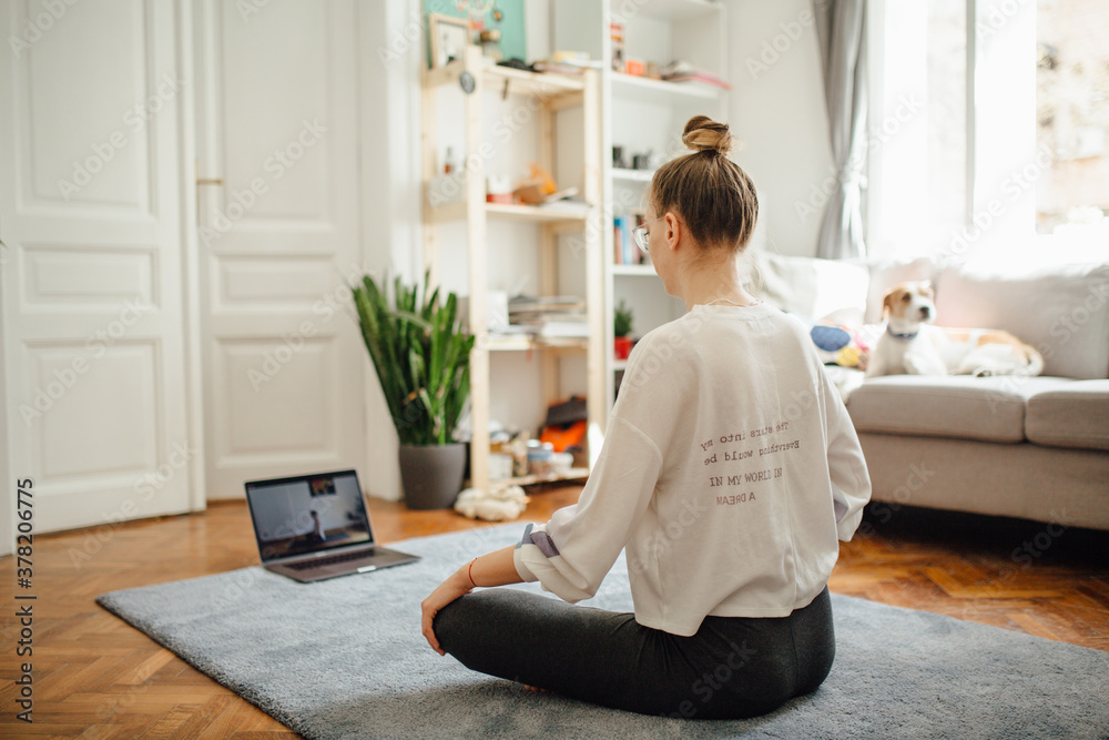 Girl In A Lotus Position Following An Online Yoga Class Girl In A Lotus Position Following An Online Yoga Class