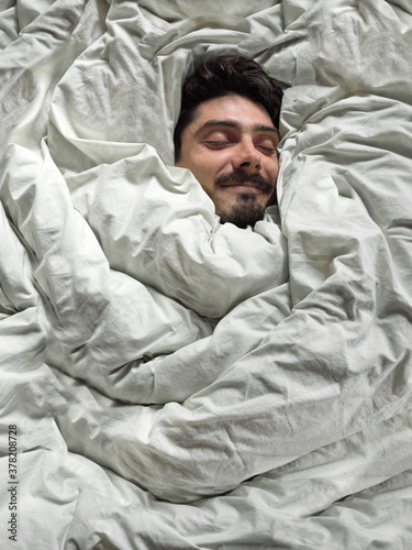 Young man wrapped in a blanket