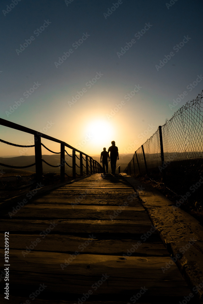 Obraz premium silhouette of a person walking on the pier