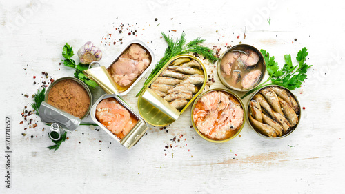 Canned fish in tin cans: Salmon, tuna, mackerel and sprats. Top view. Free space for your text.