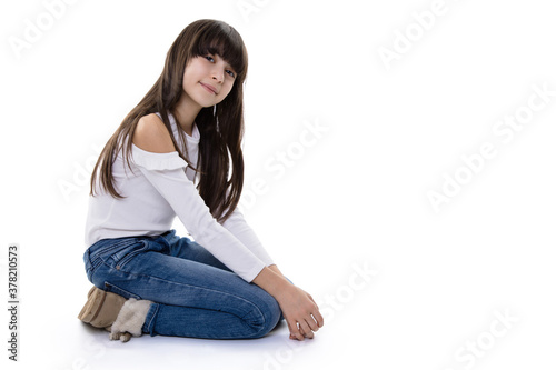 brunette girl kneel on floor and smile into camera with light angled head while being happy