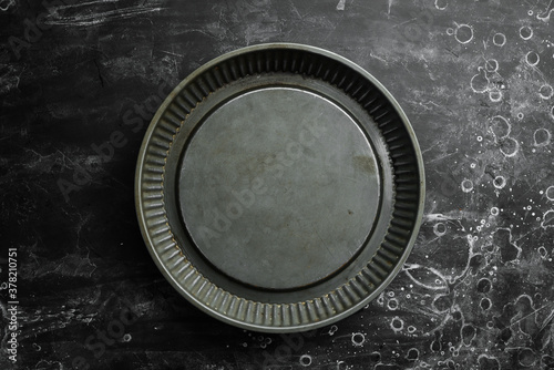 Metal kitchen form for baking food. On a black background. Top view. Free copy space.