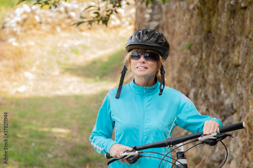 woman with bicycle and helmet outdoors