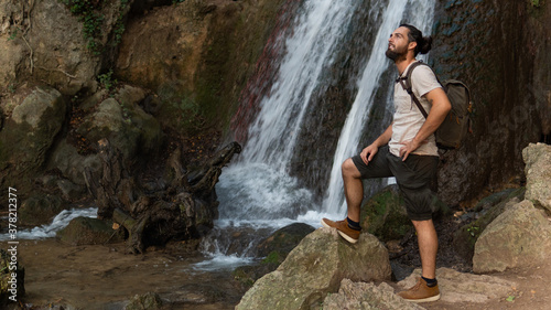 A Man Standing In Front Of A Huge Water Fall