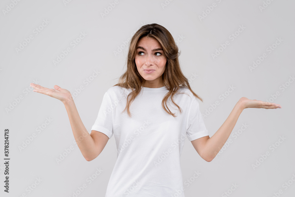 Portrait of a young woman with arms out and shruging shoulders isolated over grey background. Human emotions, facial expression, body language Portrait of a young woman with arms out and shruging shoulders isolated over grey background. Human emotions, facial expression, body language