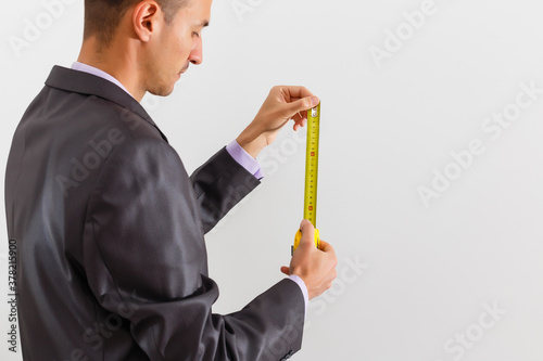 Businessman holding measurement tape, isolated on white background