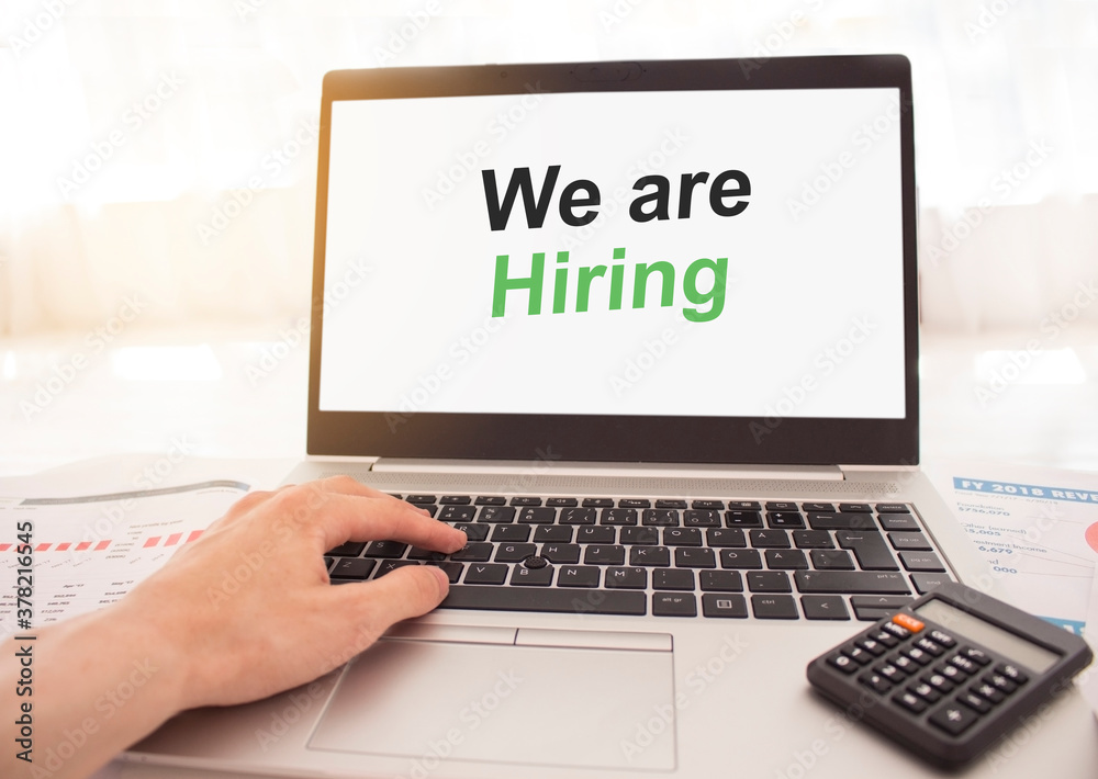 laptop with words We are hiring on white screen, business and finance concept. laptop with words We are hiring on white screen, business and finance concept.