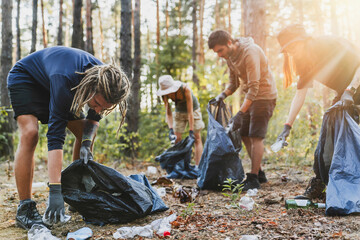 Young men and women picking up litter in forest