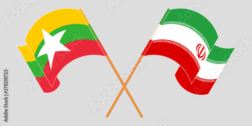 Crossed and waving flags of Myanmar and Iran