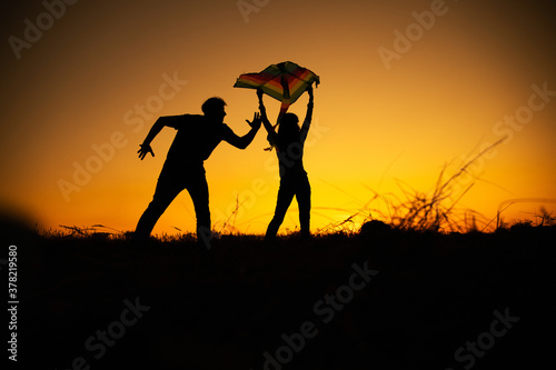 Young couple enjoying the sunset in the meadow 