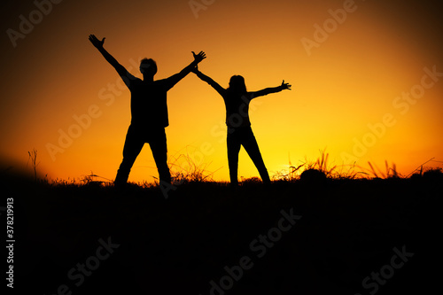 Happy cheering couple enjoying sunset. Holidays  vacation  love and friendship concept. Love couple. 