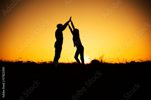 Young couple enjoying the sunset in the meadow. Couple in love. 