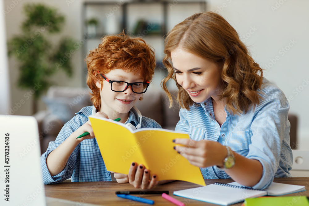 Mother helping child with homework, looks at her son's notebook at home. Mother helping child with homework, looks at her son's notebook at home.