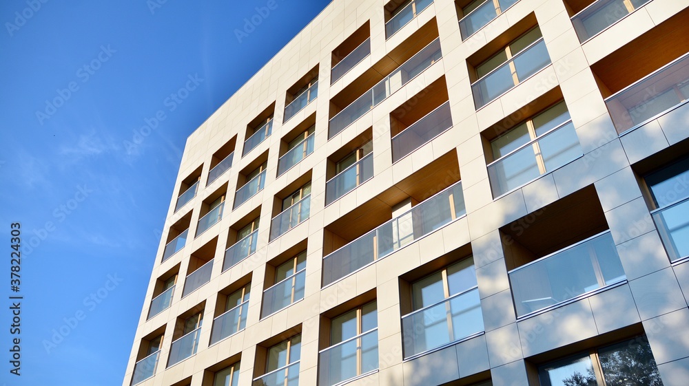 Contemporary residential building exterior in the daylight. Modern apartment buildings on a sunny day with a blue sky. Facade of a modern apartment building