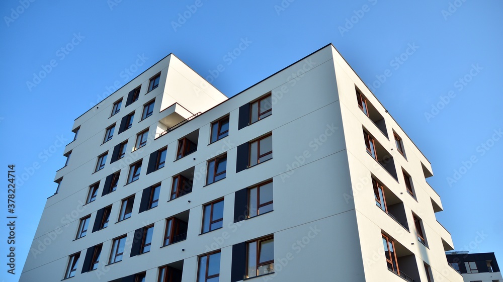 Contemporary residential building exterior in the daylight. Modern apartment buildings on a sunny day with a blue sky. Facade of a modern apartment building