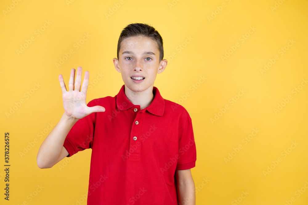 Young beautiful child boy over isolated yellow background showing and pointing up with fingers number five while smiling confident and happy Young beautiful child boy over isolated yellow background showing and pointing up with fingers number five while smiling confident and happy
