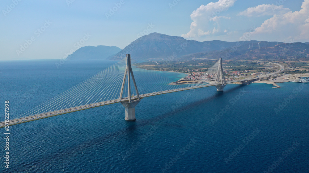Obraz premium Aerial drone photo of world famous cable suspension bridge of Rio - Antirio Harilaos Trikoupis, crossing Corinthian Gulf, mainland Greece to Peloponnese, Patras