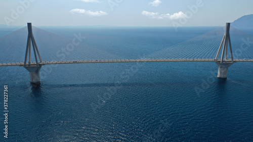 Aerial drone photo of world famous cable suspension bridge of Rio - Antirio Harilaos Trikoupis, crossing Corinthian Gulf, mainland Greece to Peloponnese, Patras