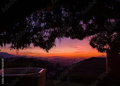 Tree framed sunset light and panorama of the old downtown photo