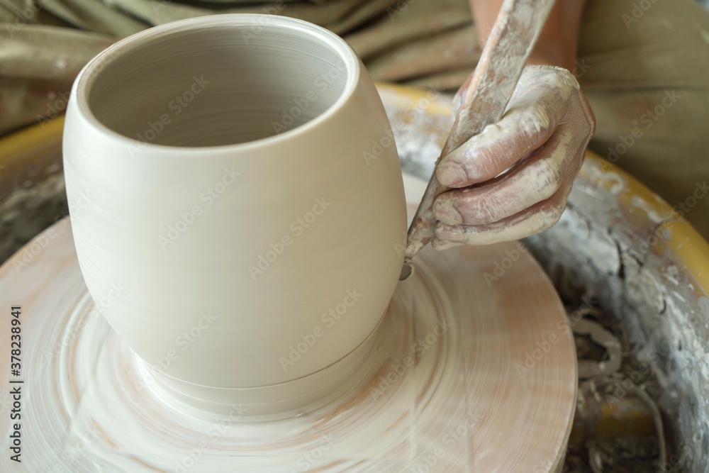 Woman making pottery on the wheel