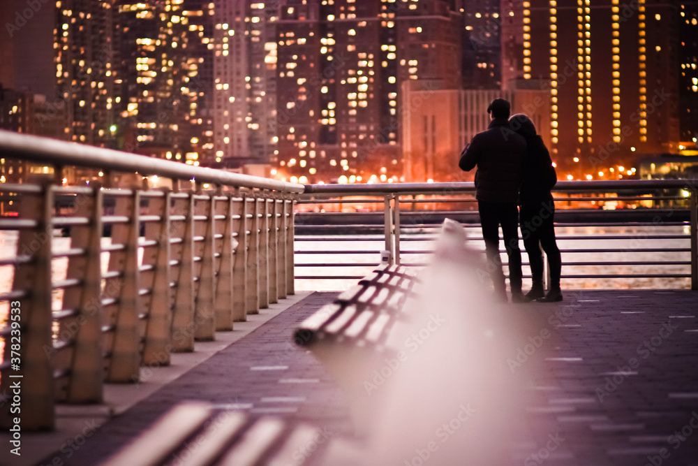 Couple standing by the river at night with bokeh lights in front love