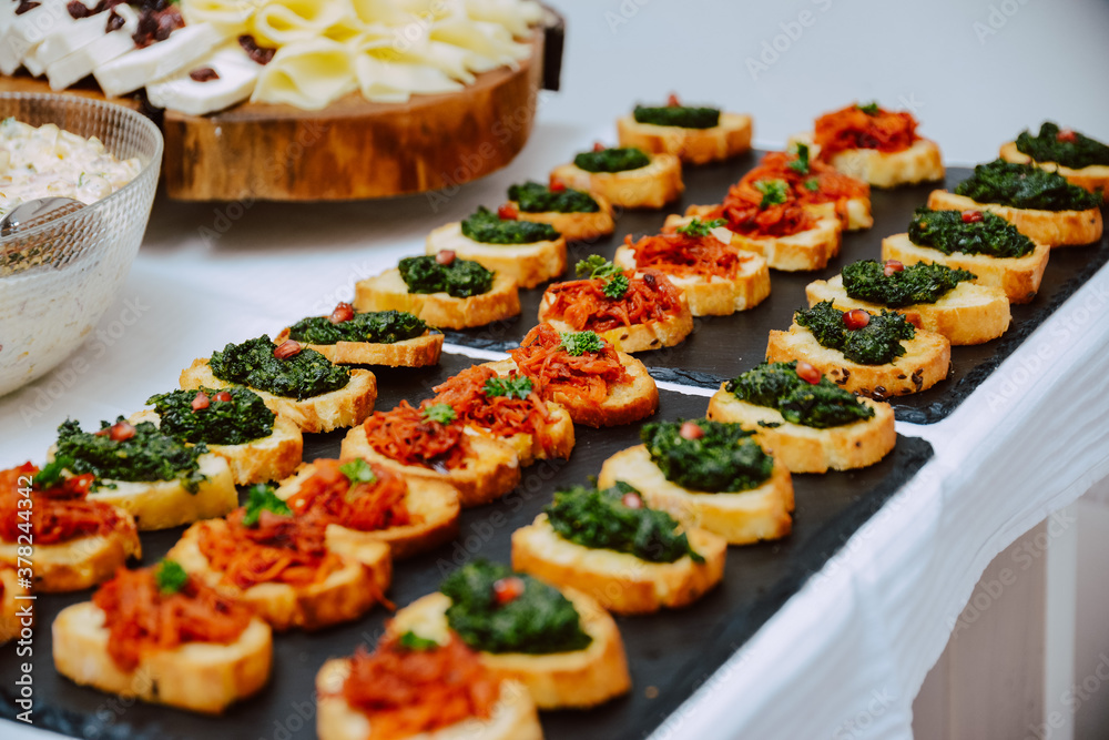 Small canapes sandwiches served on a plate at the celebration. Snack for guests Small canapes sandwiches served on a plate at the celebration. Snack for guests