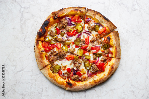 Traditional spicy italian pizza with jalapeno peppers cooked in a wood-fired oven