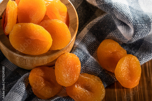 Dried apricots in bowl on fabric photo