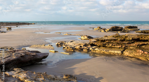 Photos Waves rolling in as the tide ebbs out on a late morning in the Indian Ocean at Cable Beach, Broome ,North Western Australia in the Summer Wet Season create a delightful tropical seascape