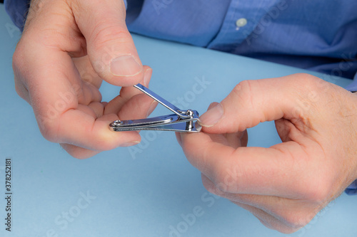 closeup as an elderly male trims a fingernail with a nail clipper