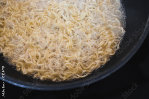 simple food ingredients, noodles cooking in pan on kitchen stove top
