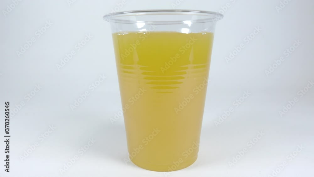 プラスチックカップに入れたオレンジジュース プラスチックカップに入れたオレンジジュース