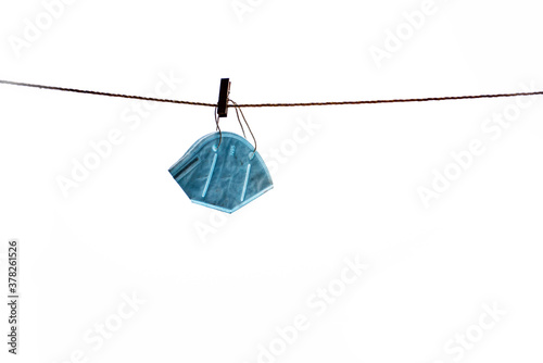 Face mask is hanging from rope on isolated white background