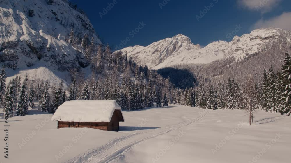 Aerial video of idyllic winter house on a beautiful sunny day with mountains in the background Aerial video of idyllic winter house on a beautiful sunny day with mountains in the background