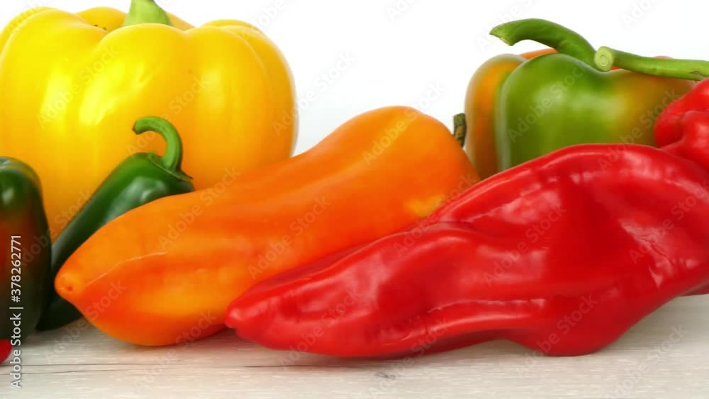 Close up left to right overview of various beautiful peppers in different shapes, sizes and colors. From big and mild to small and spicy, on a white background. Close up left to right overview of various beautiful peppers in different shapes, sizes and colors. From big and mild to small and spicy, on a white background.
