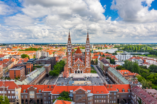 Szeged, Hungary - Aerial panoramic view of the Votive Church and Cathedral of Our Lady of Hungary (Szeged Dom) on a sunny summer day with Inner Town Bridge (Belvarosi hid) and blue sky and clouds photo