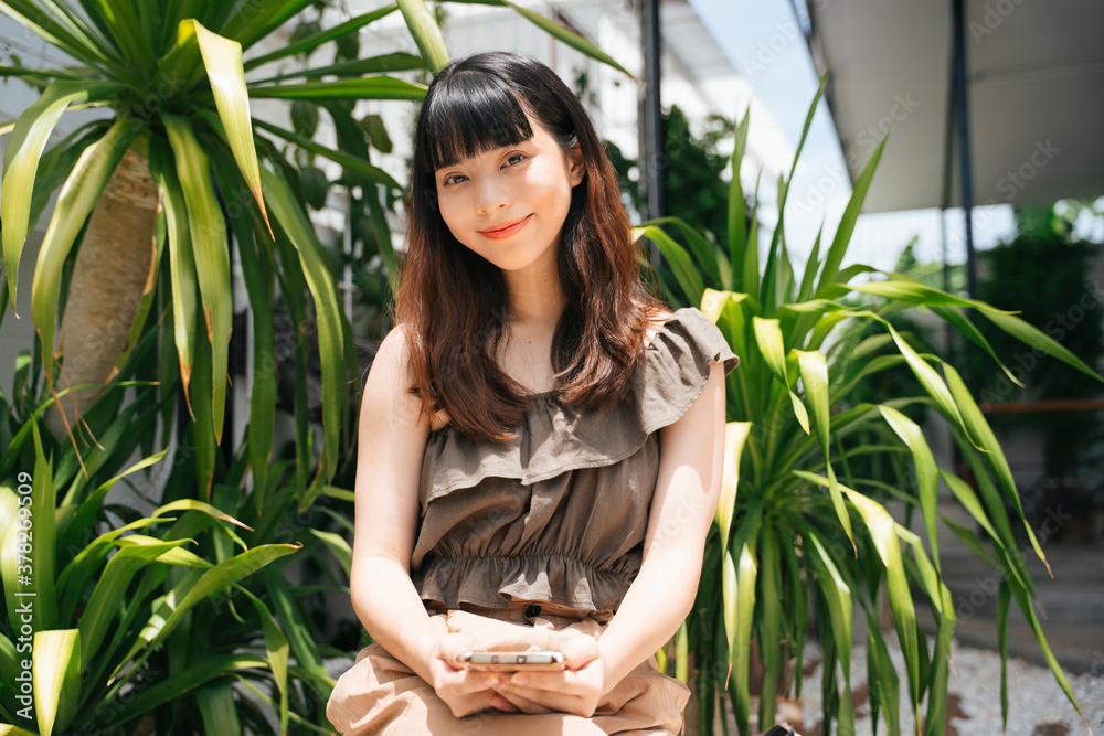 Portrait of young asian woman traveler using smartphone outdoors. Portrait of young asian woman traveler using smartphone outdoors.