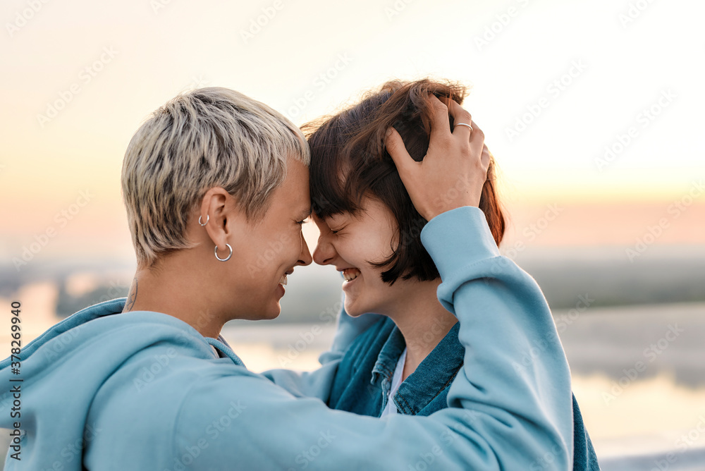 Close up of young loving lesbian couple looking happy together, Two girls hugging, cuddling and laughing before kiss Close up of young loving lesbian couple looking happy together, Two girls hugging, cuddling and laughing before kiss