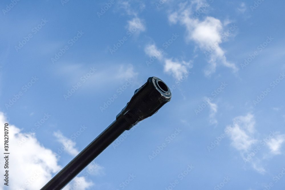Fototapeta premium barrel of an artillery piece against a blue sky close-up