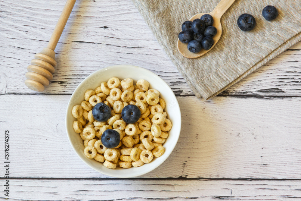 Honey rings with blueberries in a bowl on the wooden background. Copy space. Top view. Flat lay. Horizontal orientation. Honey rings with blueberries in a bowl on the wooden background. Copy space. Top view. Flat lay. Horizontal orientation.