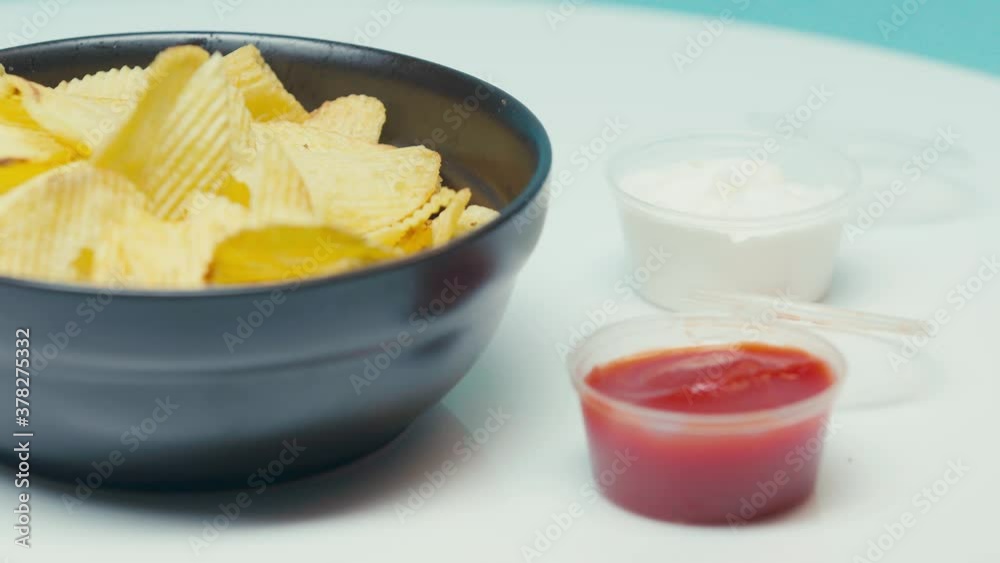 Selective focus of man dipping ridged chips in mayonnaise Selective focus of man dipping ridged chips in mayonnaise