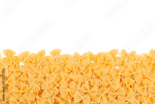 Italian pasta border for menu design template, raw farfalle over white background with copy space. Uncooked raw farfalle pasta on white background. Space for text